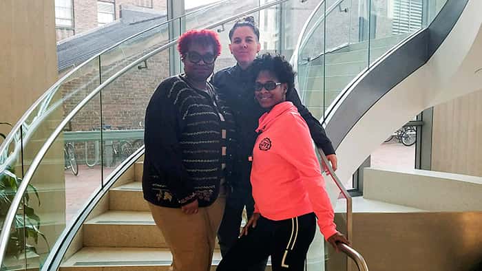 Dionne Greenhill, Maria Altonen, and Nakisha Spellman posing on a staircase