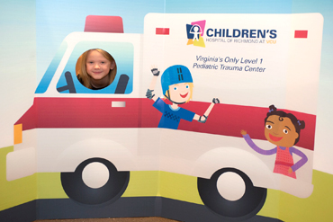 Child posing with a CHoR ambulance cutout 