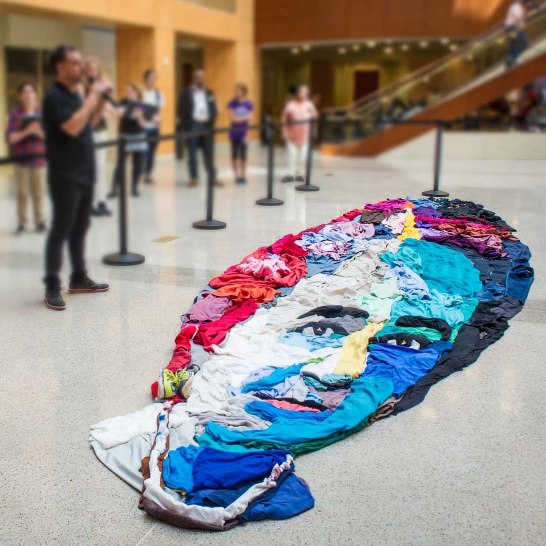 Large-scale portrait of Maggie Walker made out of colorful clothes arranged on the floor of the business school’s atrium.