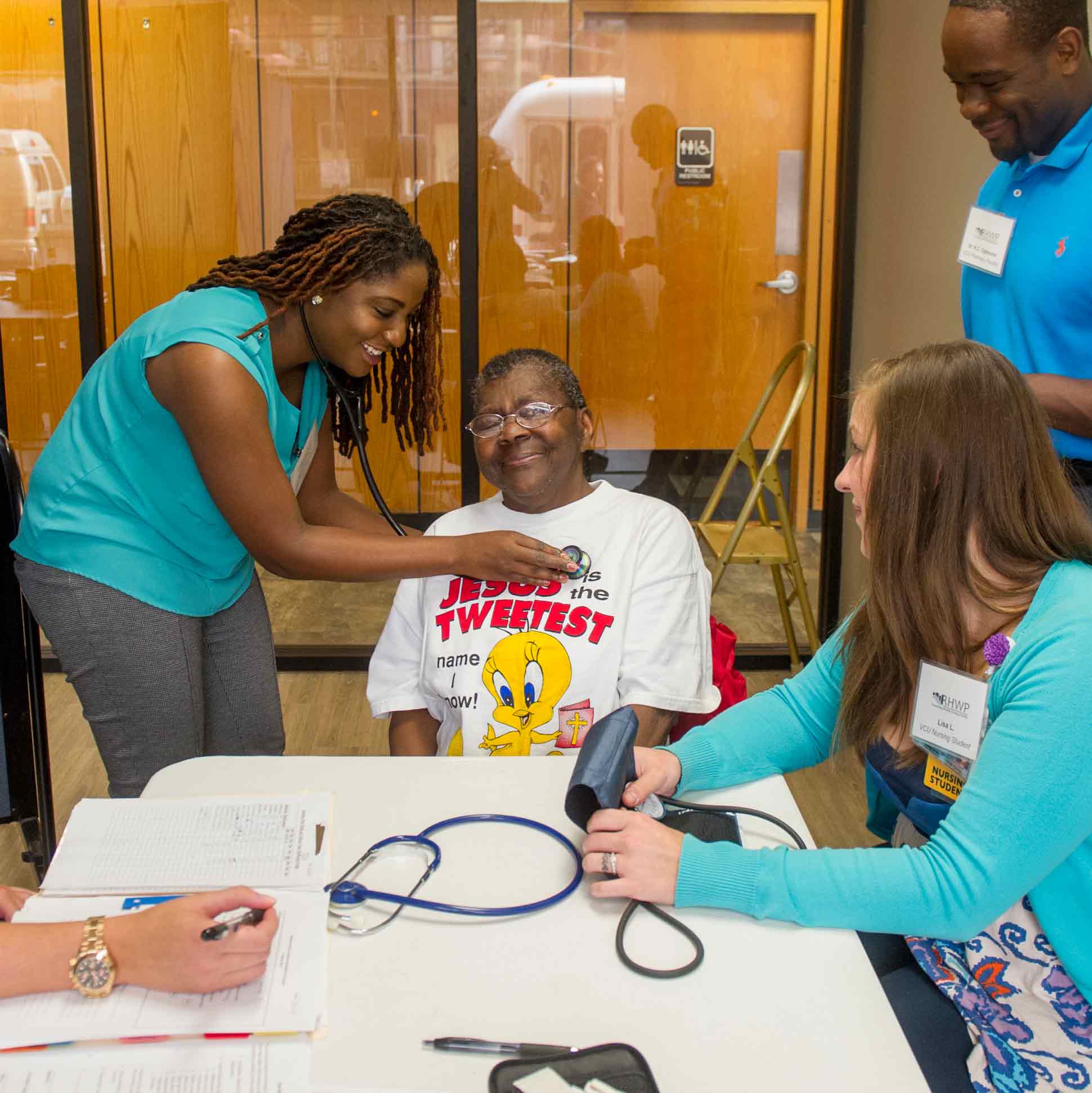 Nursing student checks heartbeat of older, male patient