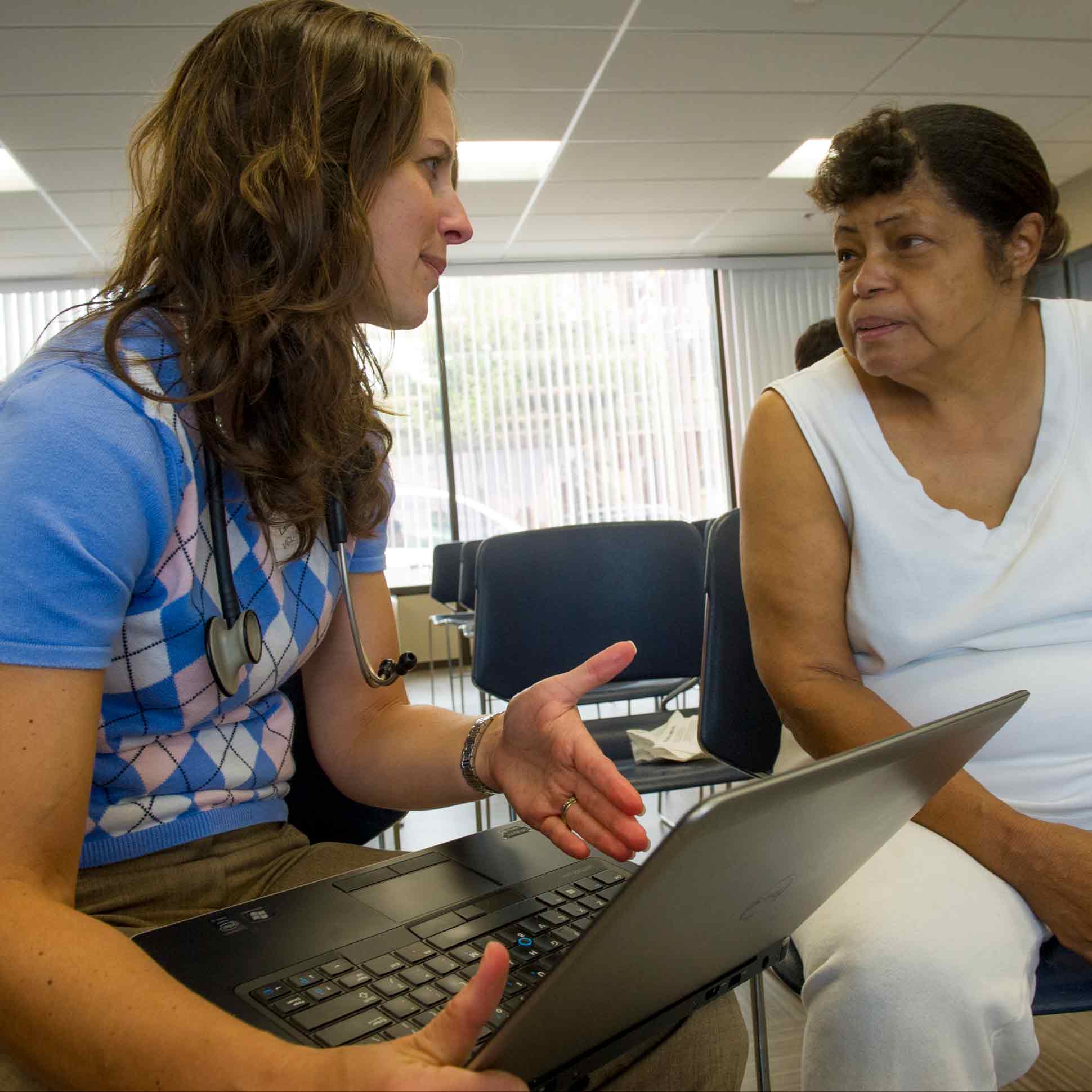 Student conducts a health assessment with an older female resident.