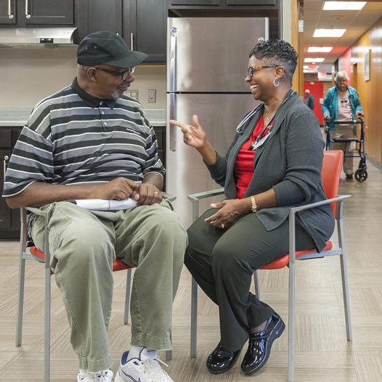 Nurse practitioner and Dominion Place resident sit together and talk
