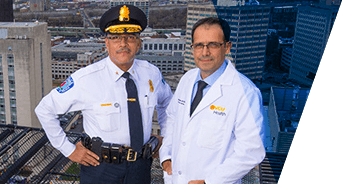 Alfred Durham and Michel Aboutanos, M.D., standing on top of building with the city in the background