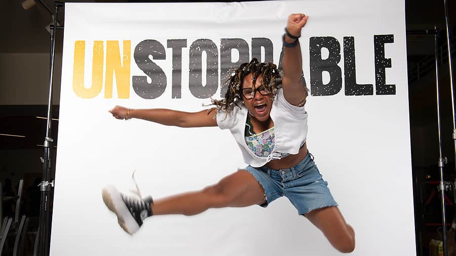 Young woman jumping in an active pose for the VCU brand launch student photo shoot.
