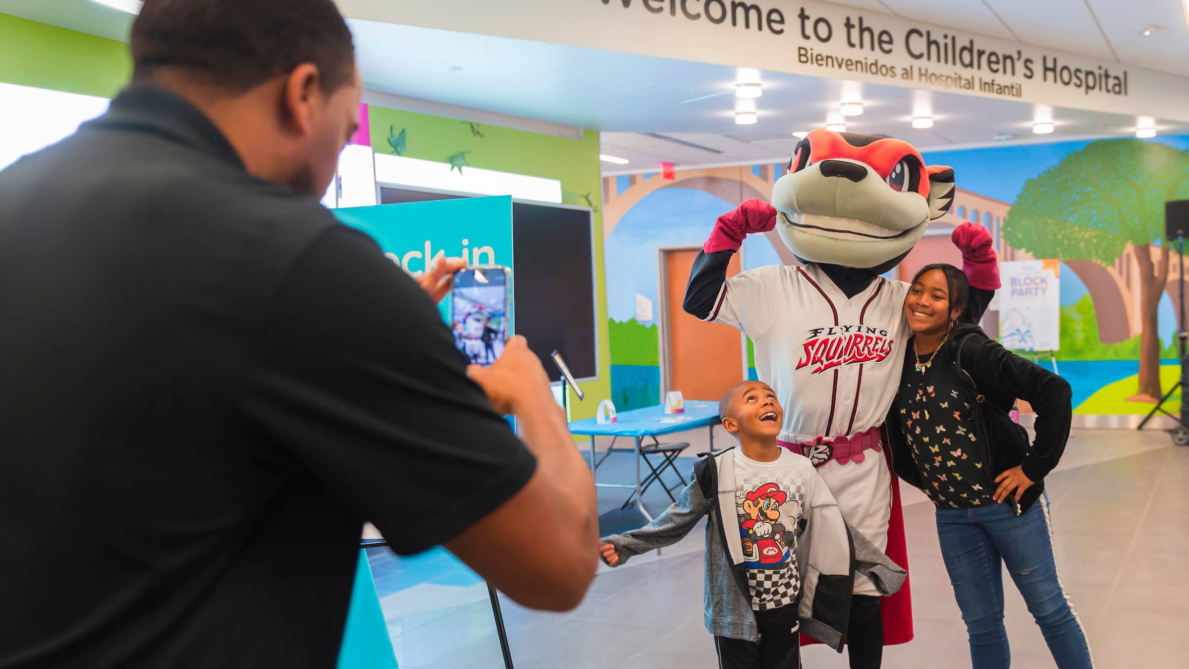 Two children pose for a photo with Nutzy, the mascot for The Flying Squirrels, in the new Children’s Tower.