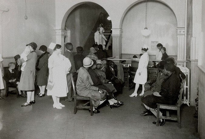 White patients stand on one side of the waiting room